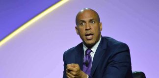 Cory Booker speaking on stage in a suit and tie