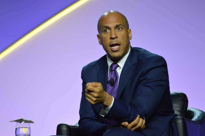 shutterstock_1462049714-1 Cory Booker speaking on stage in a suit and tie