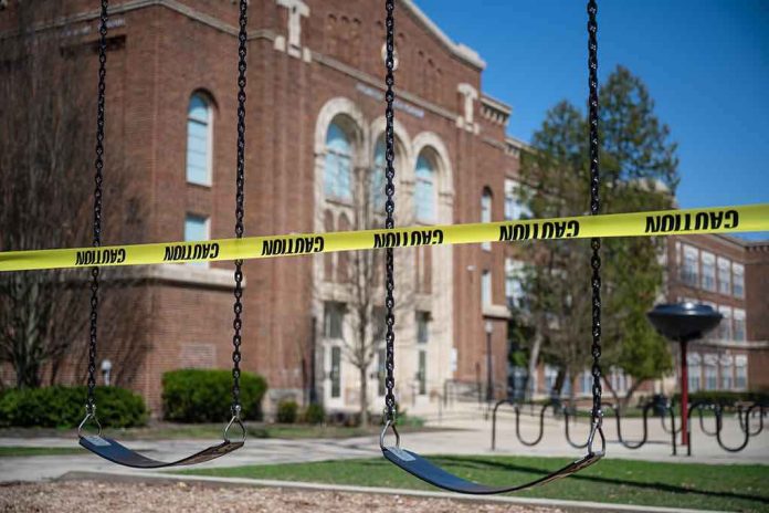 Playground swings blocked with caution tape in front of a brick school
