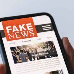 906 FAKE News Reports Traced to This Country Smartphone showing a news site with a bold fake news banner