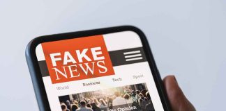 Smartphone showing a news site with a bold fake news banner