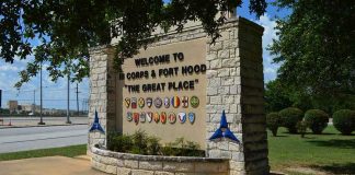 stone entrance sign with military unit emblems