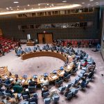 Housing Vote Sends Thousands Into Streets Delegates seated around a circular conference table in a large chamber