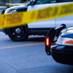 Reporter Nearly HIT After Heated Confrontation Police cars behind yellow caution tape at a street scene