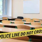 Fake Teacher Accused of RACIAL Slurs Against Students Empty classroom with police tape across desks