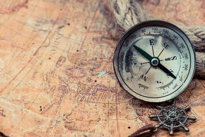 Compass on an old world map with rope and nautical charm
